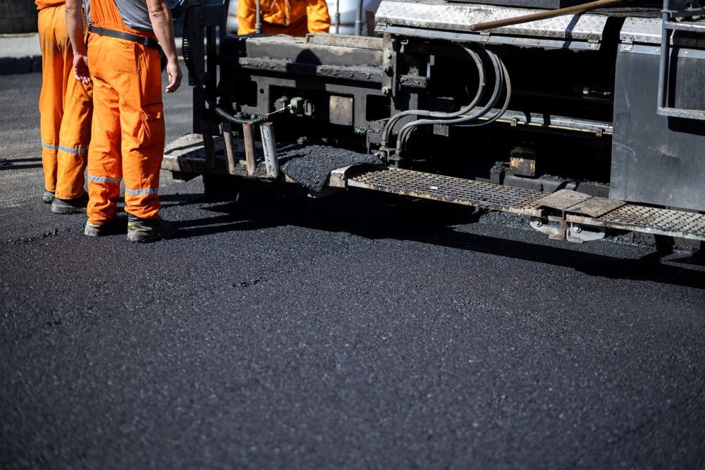Tarmac contractor applying a new layer of tarmac to a road surface