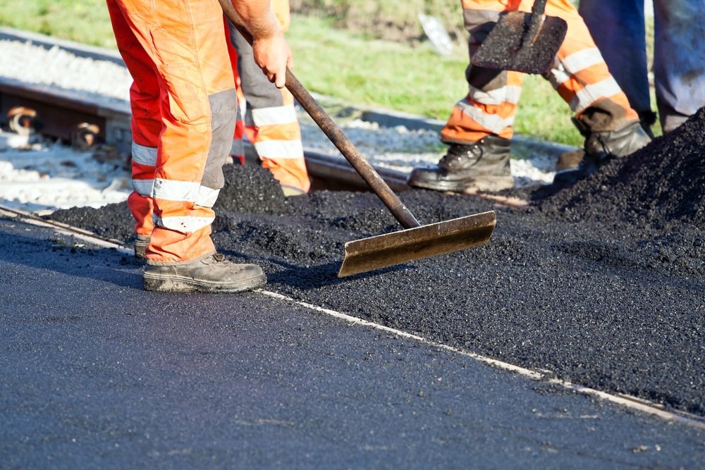 Workers repairing a road, showcasing the process of maintenance