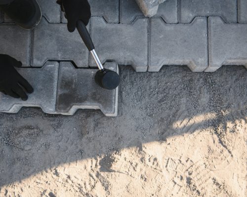 Landscaping,Paver,Worker,Laying,Paving,Stones,On,Sandy,Ground,Of