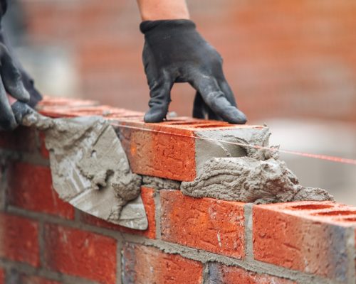 Skilled,Mason,Laying,Bricks,With,Precision,And,Attention,To,Detail