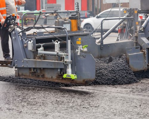 road-worker-in-an-orange-vest-controls-the-paving-2025-02-09-00-31-17-utc road-worker-in-an-orange-vest-controls-the-paving-2025-02-09-00-31-17-utc